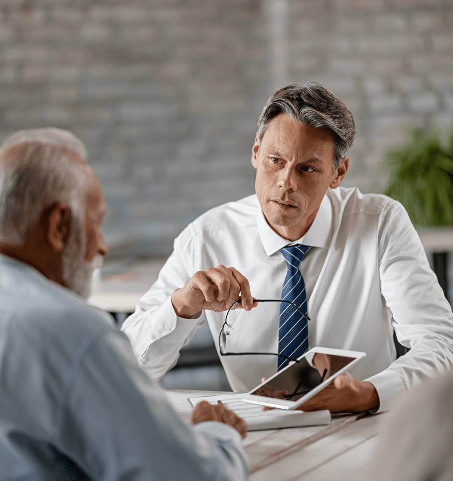 Male insurance broker showing documents to old male business owner on tablet